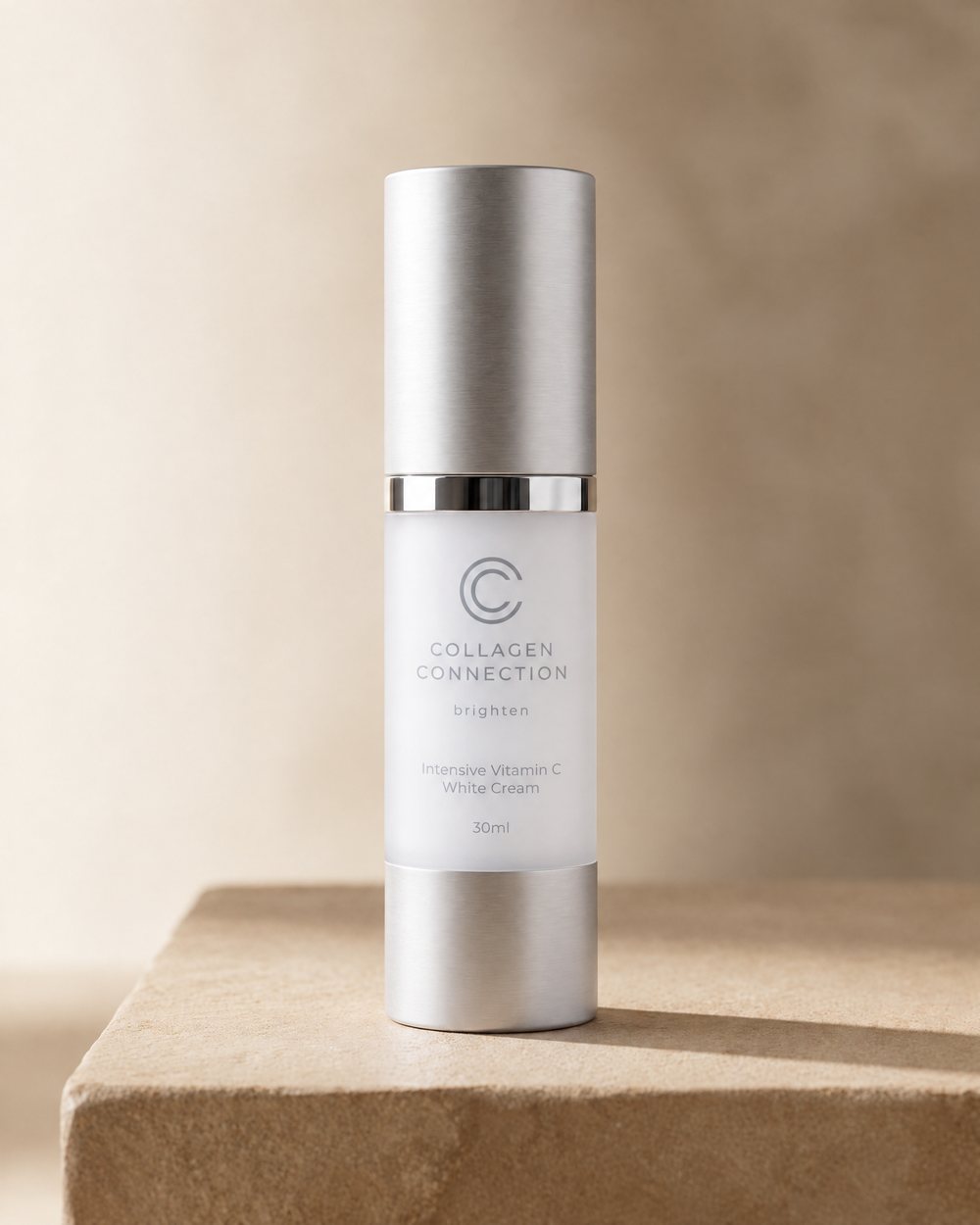 Intensive Vitamin C White Cream, 30 ml frosted pump bottle with a silver cap on travertine stone